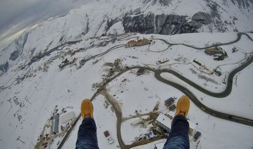 Low section of man over snow covered landscape