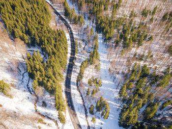Winding road from high mountain pass, in winter. aerial view by drone . romania