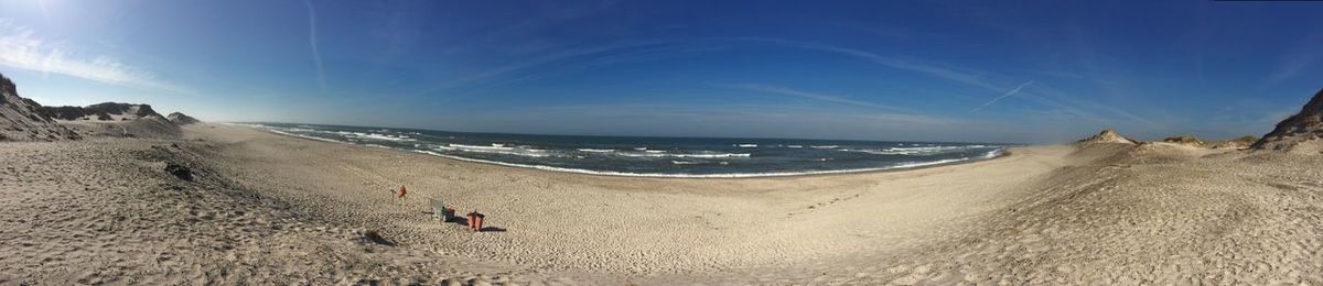 View of calm beach against blue sky