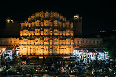 People on illuminated building at night