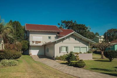 House and trees against blue sky