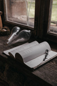 Close-up of open book on window sill