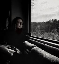 Young woman looking through window