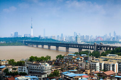 Buildings by bridge against sky in city