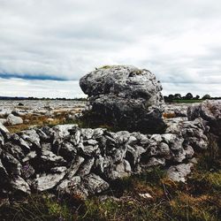 Scenic view of sea by cliff against sky