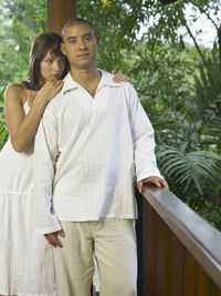 Young couple standing by railing in balcony