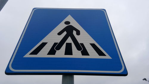 Low angle view of road sign against blue sky