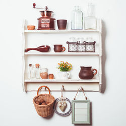 Close-up of wine bottles on shelf against white background