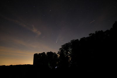 Low angle view of silhouette trees against sky at night