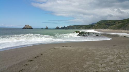 Following the footsteps left behind on beach against ocean