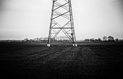Electricity pylon on field against clear sky