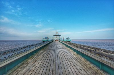 Scenic view of pier over sea against blue sky