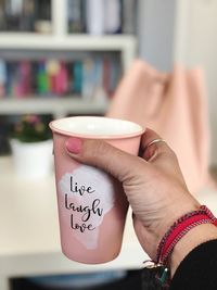 Midsection of woman holding coffee cup