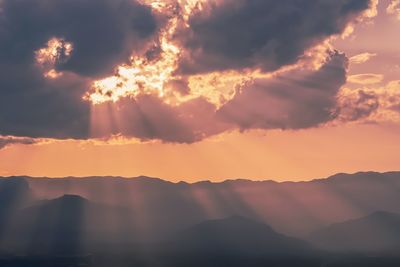 Low angle view of silhouette mountains against orange sky