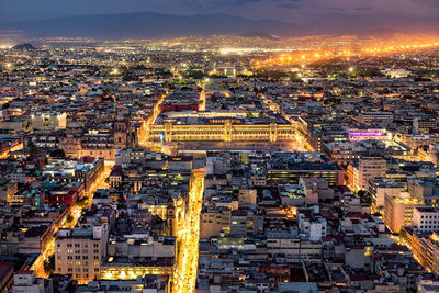 Aerial view of illuminated cityscape against sky at night