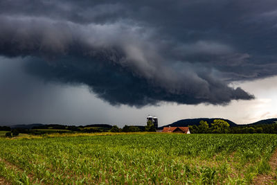 Scenic view of agricultural field against storm clouds