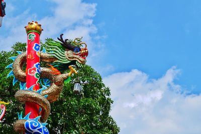 Low angle view of chinese dragon statue against blue sky