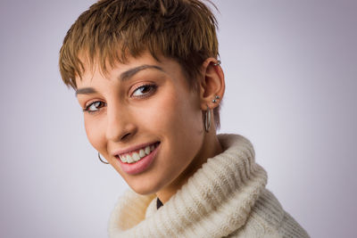 Close-up portrait of young woman against colored background