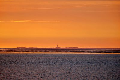 Scenic view of sea against orange sky