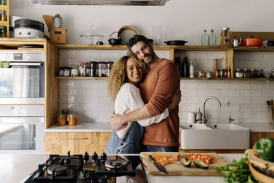 Man and woman standing in kitchen at home