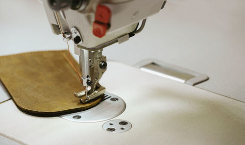 Sewing eco leather item. closeup of the sewing machine and piece of eco leather. sewing machine