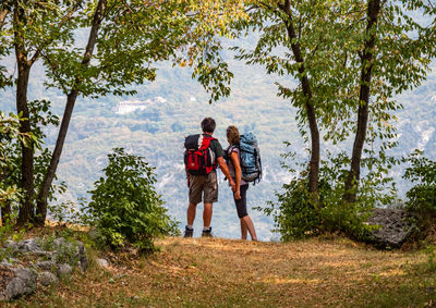 Couple with backpacks standing against mountain