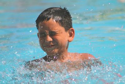 Close-up of shirtless boy swimming in pool