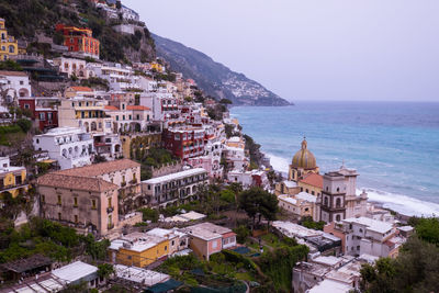 High angle view of townscape by sea against sky