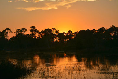 Scenic view of lake against orange sky