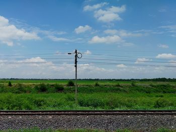 Electricity pylons on field against sky