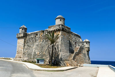 Low angle view of historic building against blue sky