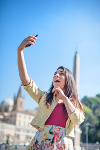 Women taking selfie against clear blue sky