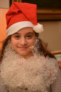 Portrait of smiling girl in santa hat at home