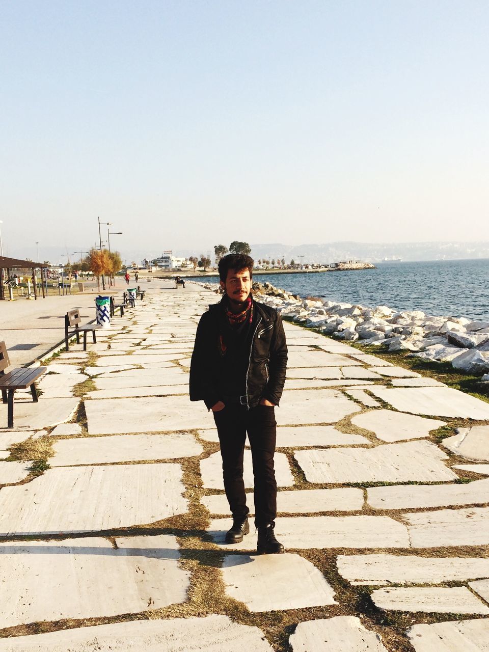 one person, looking at camera, clear sky, portrait, beach, real people, young adult, one young man only, full length, leisure activity, outdoors, front view, adults only, day, men, one man only, standing, sea, only men, sky, adult, people