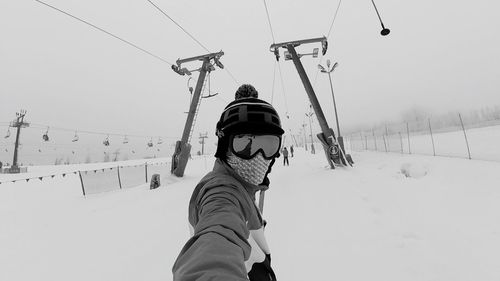 Low angle view of overhead cable car against sky during winter