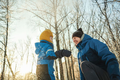 Friends on snow covered trees during winter