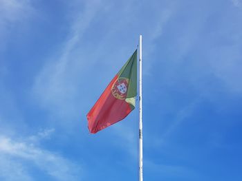 Low angle view of flag against blue sky