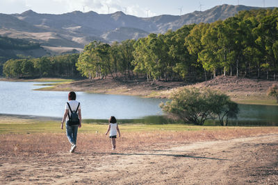 Rear view of woman walking on lake