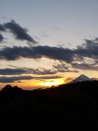Silhouette landscape against sky during sunset