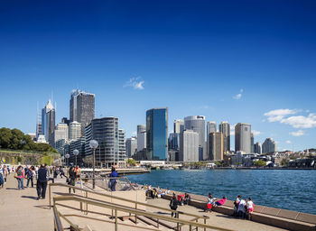 Group of people in city by buildings against sky