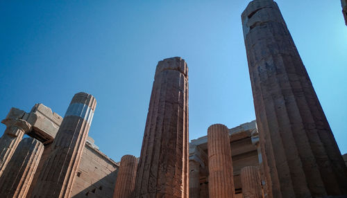 Low angle view of skyscrapers against blue sky