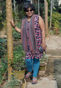 Portrait of a joyful indian woman in ethnic dress standing in garden