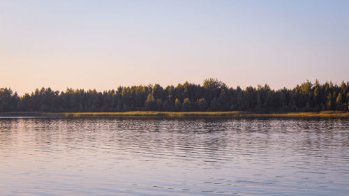 Scenic view of lake against clear sky at sunset