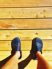 Low section of person standing on wooden floor