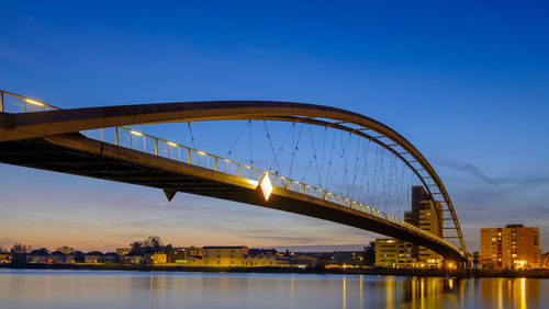 View of bridge over river at dusk