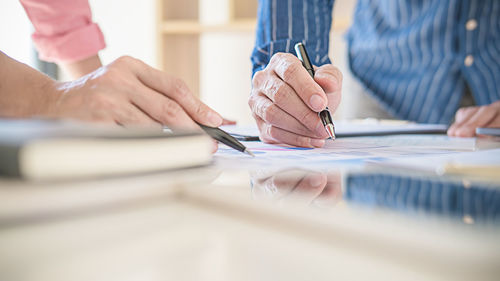 Cropped image of people working on table