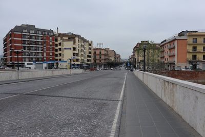 Street amidst buildings against sky in city