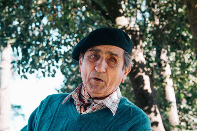 Portrait of man wearing sunglasses against trees