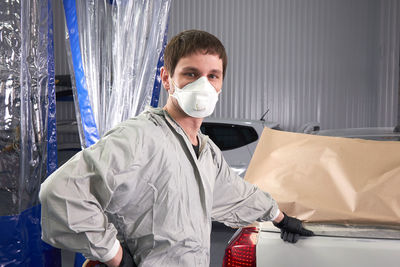 Portrait of man standing at garage