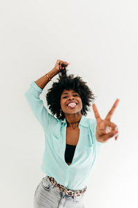 Portrait of smiling woman standing against white background